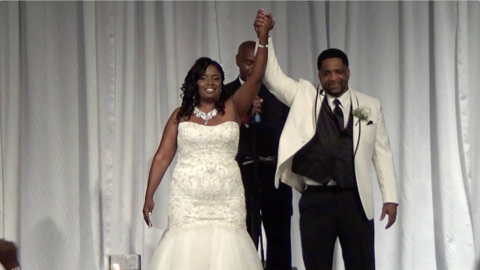 bride and groom with hands up
